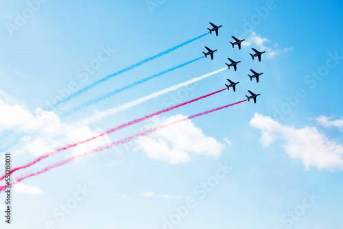 Group of planes fly with color trail in blue red white
