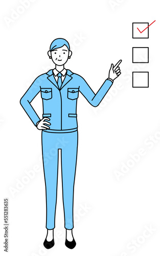 チェックリストを指さす作業着を着たシニア女性（経営者、管理職、工場長）