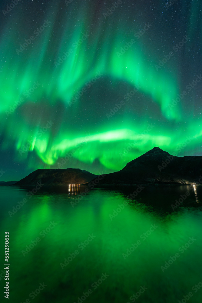 Arctic fjord reflection at night, with big aurora display - Tromso, Norway.