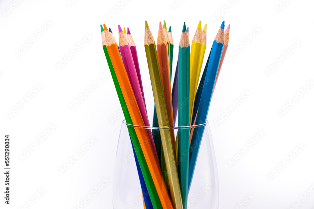 multi-colored pencils in a wine glass and a bucket. Selective blurred a group of coloring pencils in a wine glass on the isolated white or black background , Modern art. Modern multi-colored pencils in a wine glass and a bucket. Selective blurred a group of coloring pencils in a wine glass on the isolated white or black background , Modern art. Modern