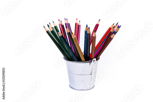 multi-colored pencils in a wine glass and a bucket. Selective blurred a group of coloring pencils in a wine glass on the isolated white or black background , Modern art. Modern