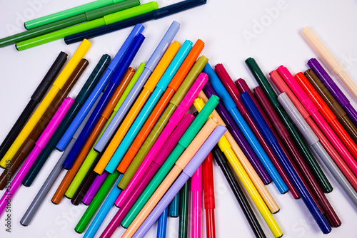 A set of multi-colored felt-tip pens in a row, rainbow on a light white banner background. Drawing markers, pencils, ink, artist tools, creativity, leisure, hobby. Colorful school supplies.