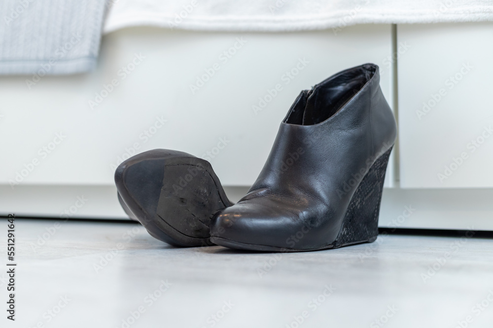 pair of black boots with high heels in front of a white closet pair of black boots with high heels in front of a white closet