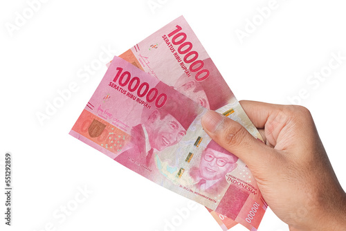 Hand holding one hundred thousand rupiah banknote isolated on a white background. financial concept