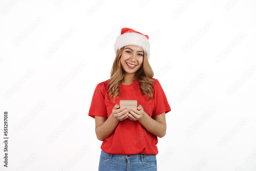 Happy asian woman in santa hat and red t-shirt isolated on white background. Holding small gift box Happy asian woman in santa hat and red t-shirt isolated on white background. Holding small gift box