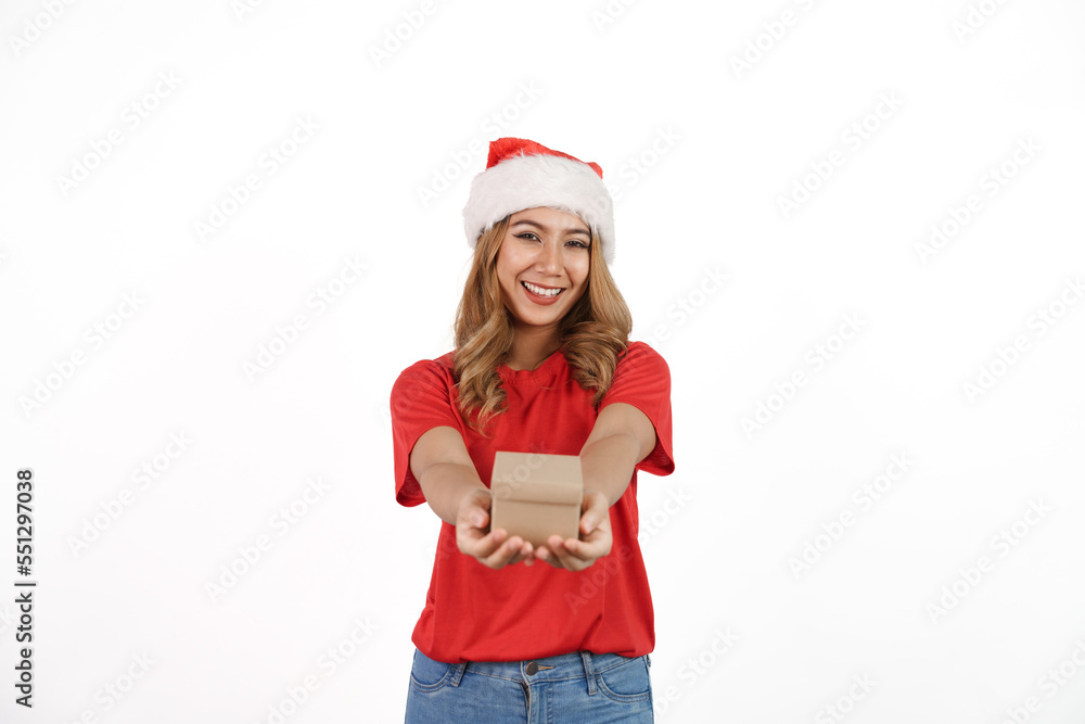 Happy asian woman in santa hat and red t-shirt isolated on white background. Holding small gift box Happy asian woman in santa hat and red t-shirt isolated on white background. Holding small gift box