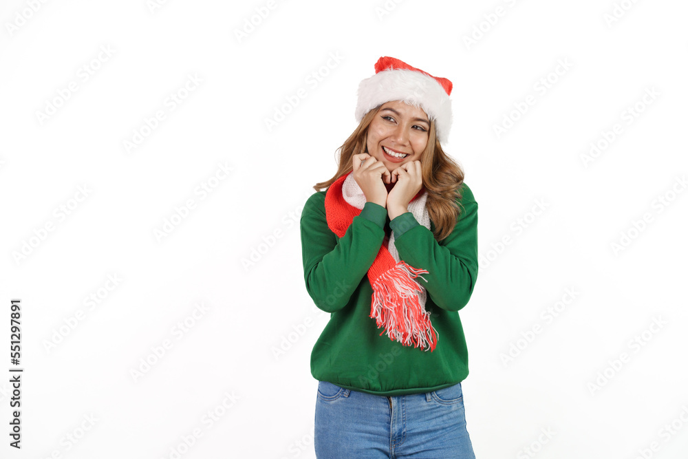 Attractive excited asian female in green sweater with santa hat on christmas isolated on white background. Attractive excited asian female in green sweater with santa hat on christmas isolated on white background.