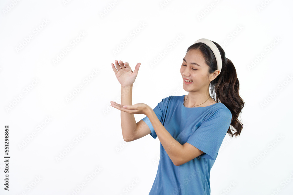 Beautiful Asian woman in blue t-shirt isolated on white background. Holding hands product Beautiful Asian woman in blue t-shirt isolated on white background. Holding hands product