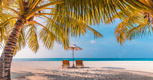 Fototapeta Naklejka Na Ścianę i Meble -  Beautiful panoramic nature. Tropical beach sunset as summer island landscape with chairs umbrella palm leaves calm sea shore, coast. Luxury travel panoramic destination banner for vacation or holiday
