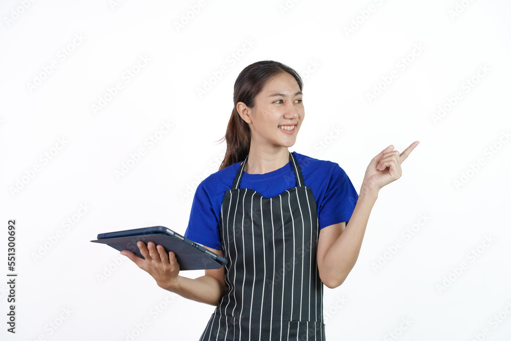Excited asian coffee shop SME owner asian woman wearing blue t-shirt and black apron isolated on white background. Holding and using tablet Excited asian coffee shop SME owner asian woman wearing blue t-shirt and black apron isolated on white background. Holding and using tablet
