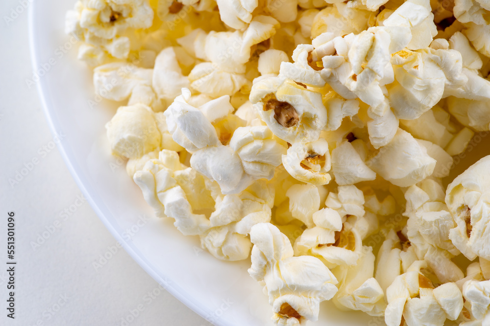 White plate with popcorn isolated on white background White plate with popcorn isolated on white background