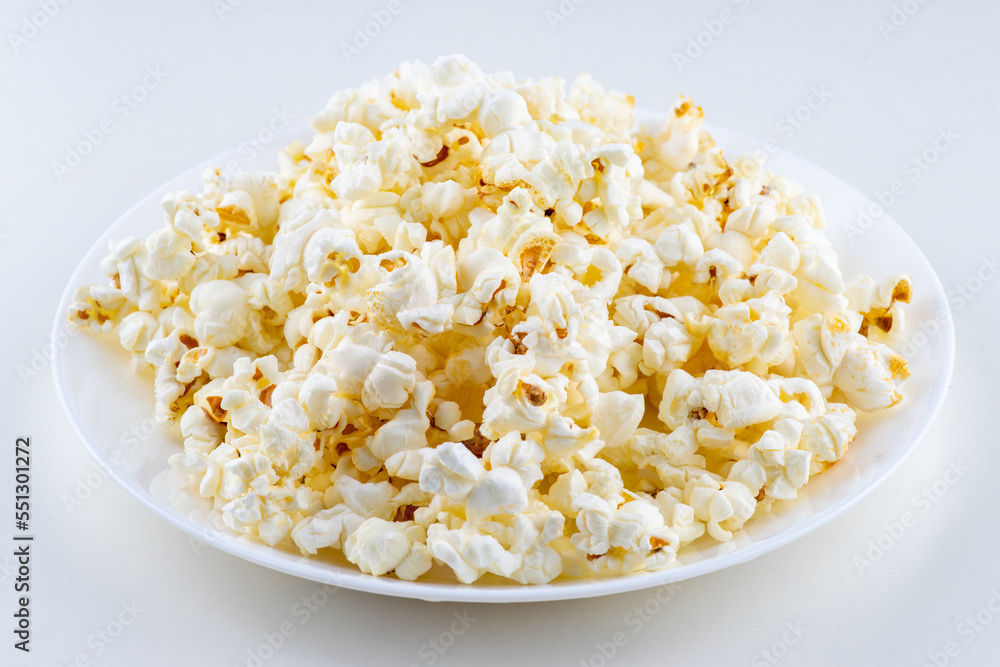 White plate with popcorn isolated on white background