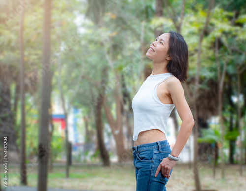 Free Download middle aged woman Asians are slender, beautiful, slender. Young women wearing white tights, jeans. look up at the sky And smile brightly in the morning, the sun shines - GFXLoad