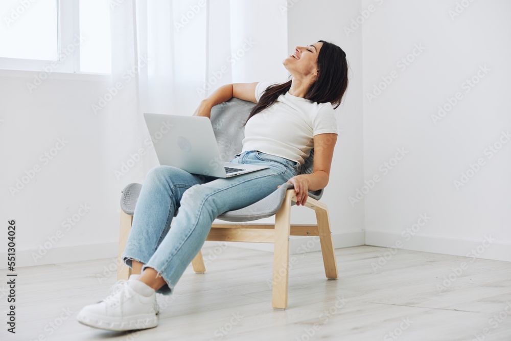 Woman relaxing at home sitting in a chair with a laptop, lifestyle home mood. Mockup, free copy space Woman relaxing at home sitting in a chair with a laptop, lifestyle home mood. Mockup, free copy space