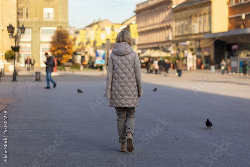 Alone woman walks ar street, rear view. Back view. Concept of psychology of loneliness