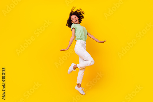 Full size photo of young pretty adorable gorgeous nice perfect woman wear stylish casual wear dancing showing sneakers isolated on yellow color background