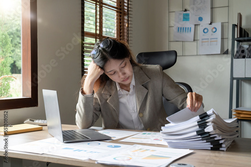 Asian business woman stressed office worker overloaded with paperwork.
