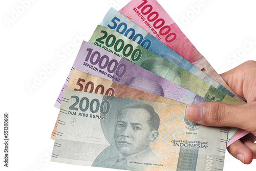 man's hand holding Indonesian rupiah banknotes photo