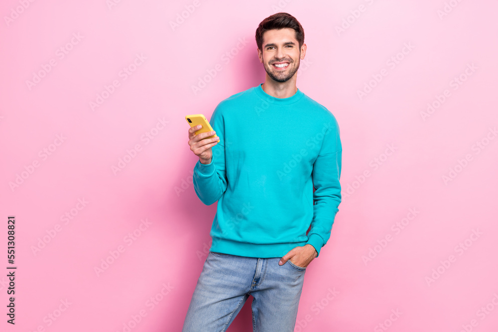 Photo of young entrepreneur working remote with his smartphone convenient app for business tasks isolated on pastel pink color background