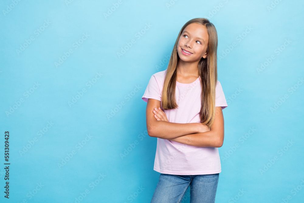 Photo of cheerful minded person crossed arms toothy smile look empty space isolated on blue color background Photo of cheerful minded person crossed arms toothy smile look empty space isolated on blue color background