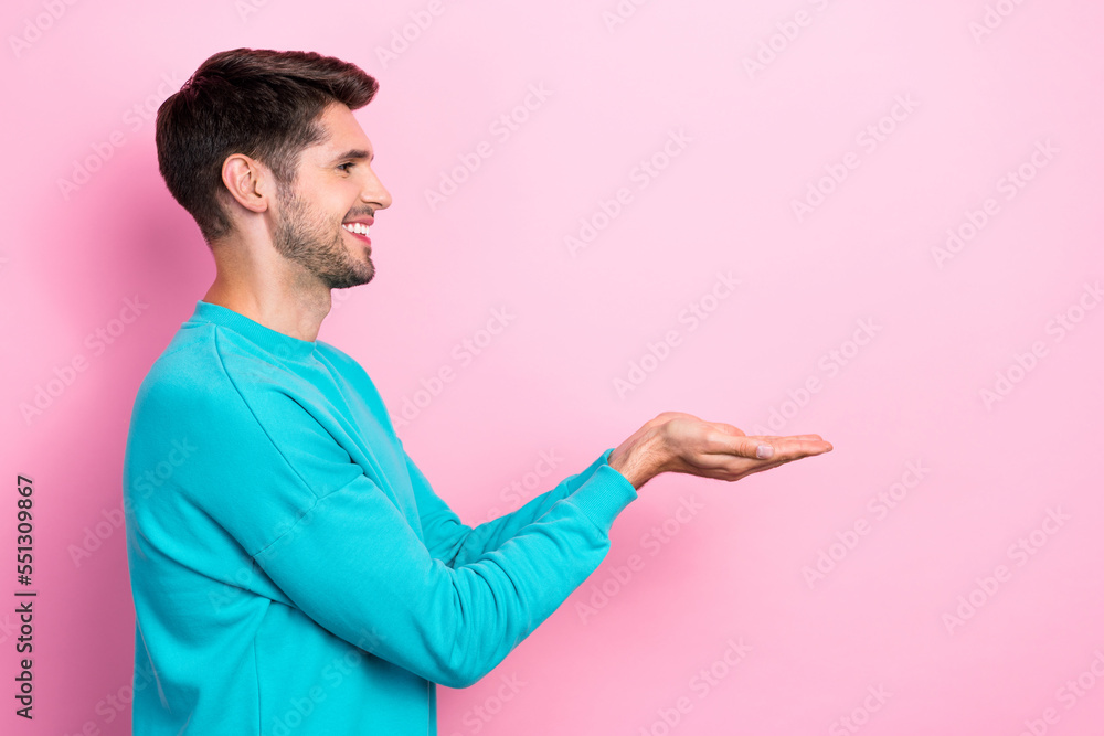 Photo portrait of handsome young man palms hold copyspace toothy smile dressed stylish blue look isolated on pink color background Photo portrait of handsome young man palms hold copyspace toothy smile dressed stylish blue look isolated on pink color background