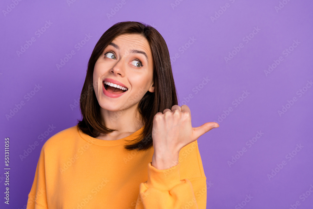 Closeup photo of funny cute girlish woman wear yellow shirt excited look finger pointing empty space ad invite halloween isolated on violet color background Closeup photo of funny cute girlish woman wear yellow shirt excited look finger pointing empty space ad invite halloween isolated on violet color background