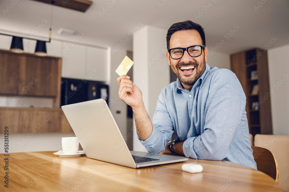 A happy man holding credit card and showing it at the camera. A happy man holding credit card and showing it at the camera.