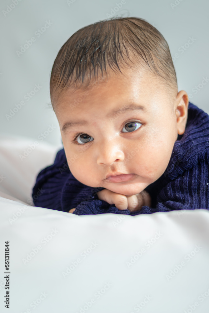 infant boy lying cute facial expression with white background at indoor infant boy lying cute facial expression with white background at indoor