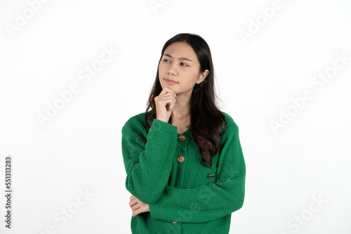 Image of thinking young lady standing isolated over white background. Looking aside. © Parichat