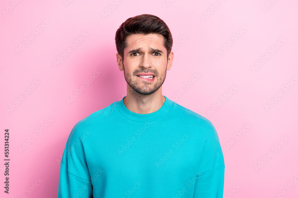 Photo portrait of handsome young man bite lips confused worried negative dressed stylish blue look isolated on pink color background Photo portrait of handsome young man bite lips confused worried negative dressed stylish blue look isolated on pink color background