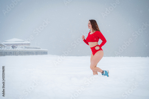 Caucasian woman dressed in shorts and top jogging in winter.