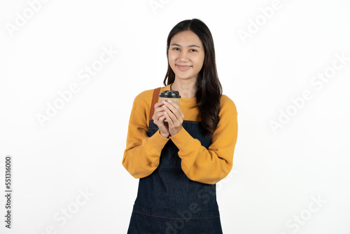 Young smiling Asian female barista bartender coffee maker woman in apron holding paper coffee cup, selling hot beverage tea isolated in white background.