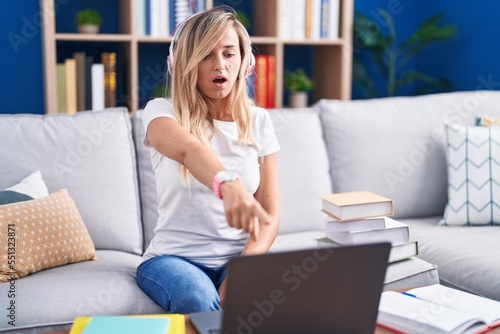 Young blonde woman studying using computer laptop at home pointing displeased and frustrated to the camera, angry and furious with you