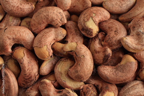 Heap of slightly roasted and salted cashews. Top-down view. Closeup. Food background