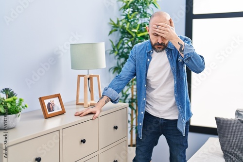 Young bald man suffering dizzy standing at home photo