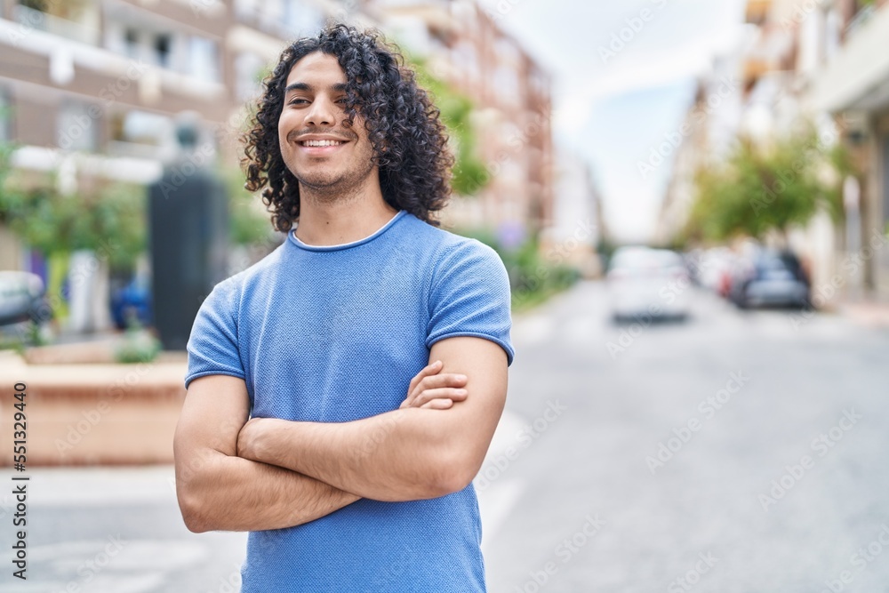 Young latin man standing with arms crossed gesture at street Young latin man standing with arms crossed gesture at street