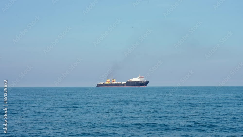 Cargo ship in sea at horizon line Cargo ship in sea at horizon line