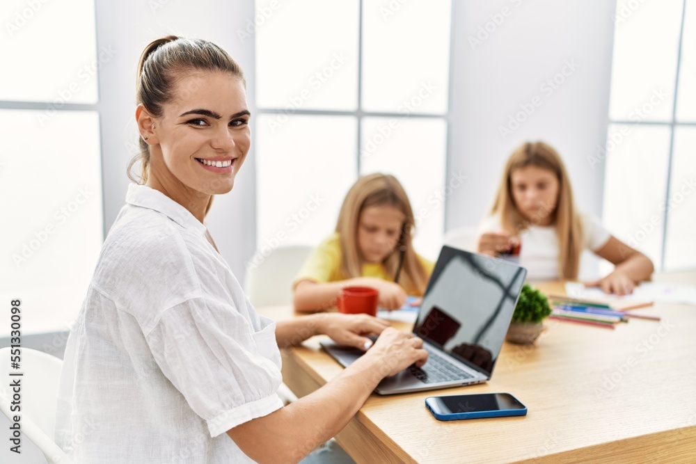 Mother and daughters smiling confident working and drawing at office Mother and daughters smiling confident working and drawing at office