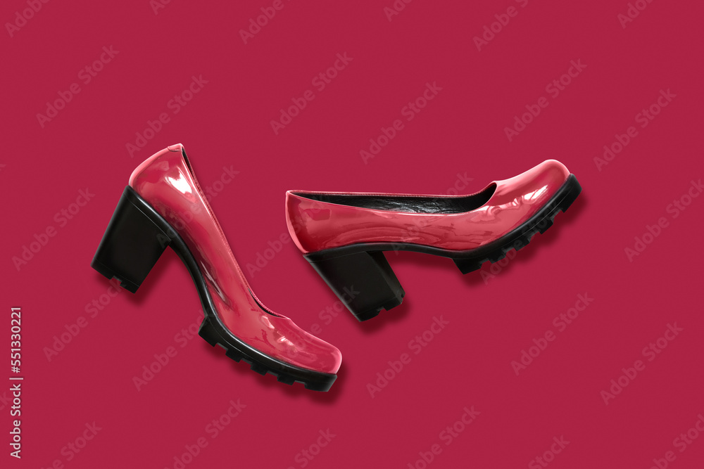 Women's viva magenta shoes of patent leather on black platform on monochrome background. Color of the Year 2023. Women's viva magenta shoes of patent leather on black platform on monochrome background. Color of the Year 2023.