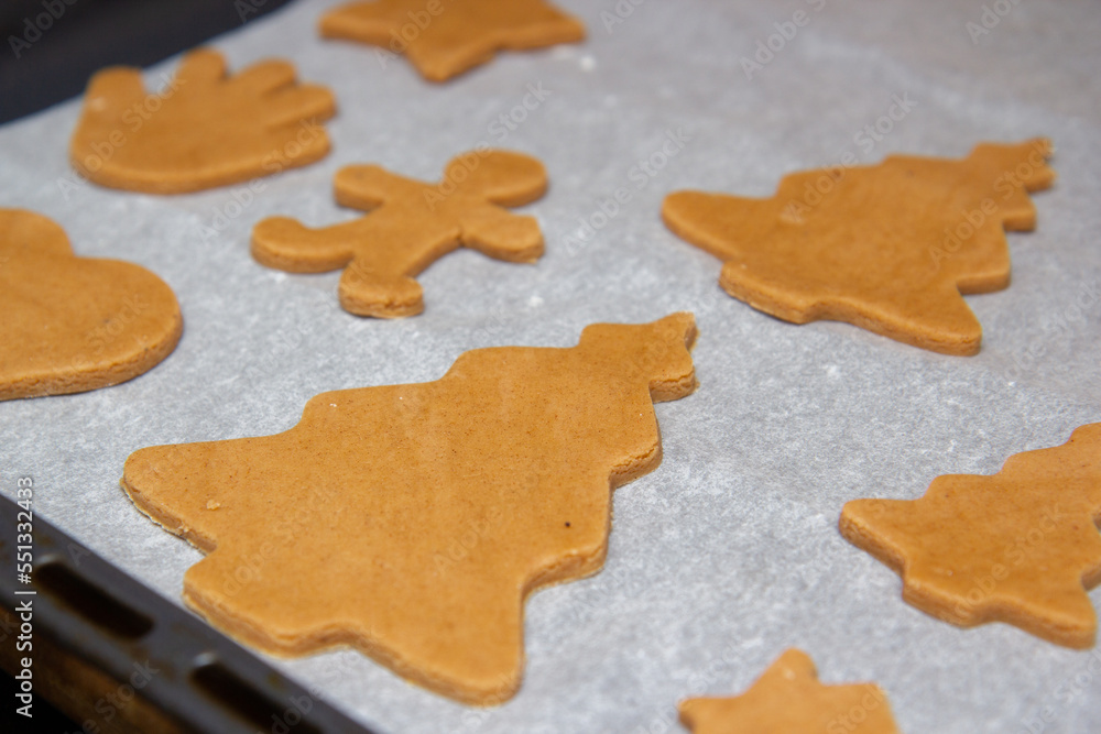 christmas gingerbread on a white parchment on a baking sheet christmas gingerbread on a white parchment on a baking sheet