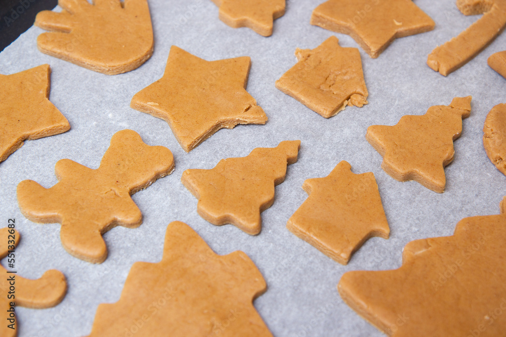 christmas gingerbread on a white parchment on a baking sheet christmas gingerbread on a white parchment on a baking sheet