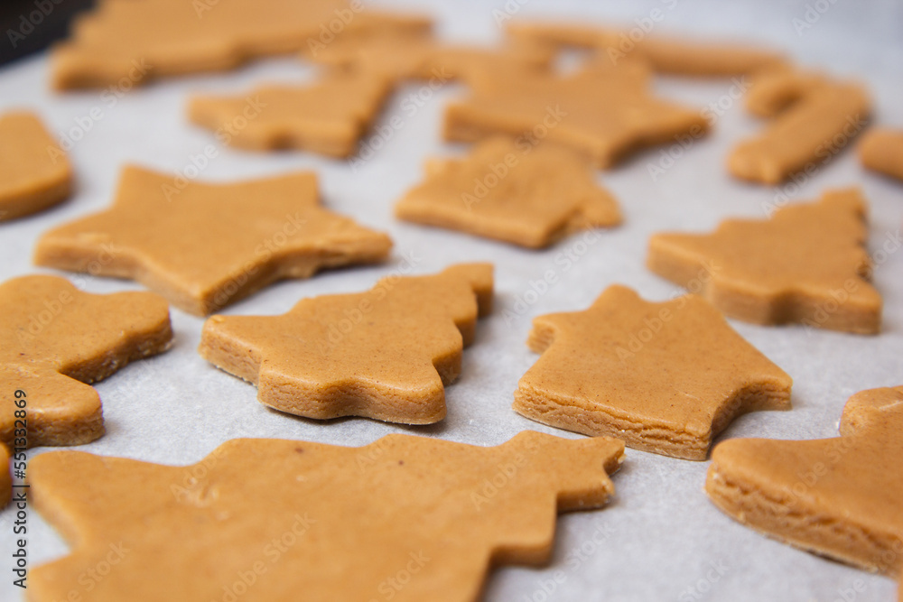 christmas gingerbread on a white parchment on a baking sheet christmas gingerbread on a white parchment on a baking sheet