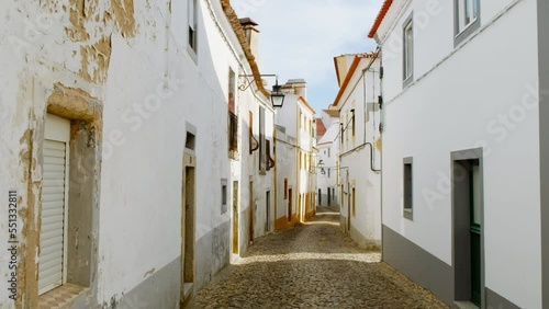 Discovering the narrow and picturesque streets of Evora, Portugal, featuring the famous whitewashed houses with yellow accents