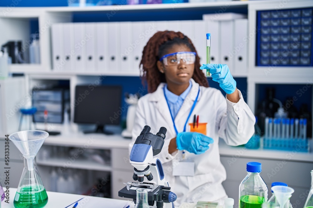 African american woman scientist holding test tube at laboratory African american woman scientist holding test tube at laboratory