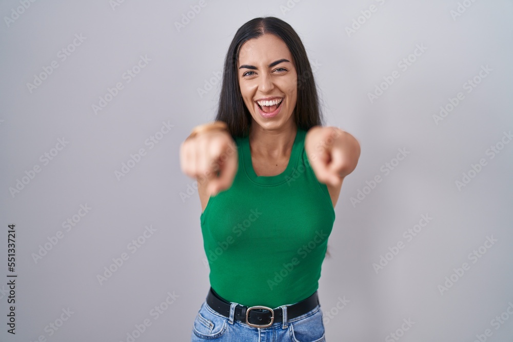 Young woman standing over isolated background pointing to you and the camera with fingers, smiling positive and cheerful Young woman standing over isolated background pointing to you and the camera with fingers, smiling positive and cheerful