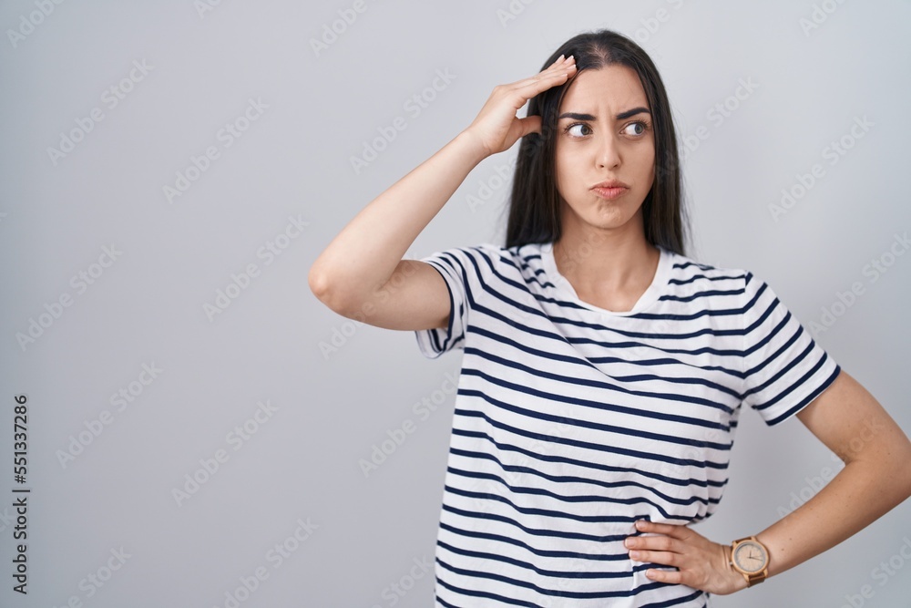 Young brunette woman wearing striped t shirt worried and stressed about a problem with hand on forehead, nervous and anxious for crisis Young brunette woman wearing striped t shirt worried and stressed about a problem with hand on forehead, nervous and anxious for crisis