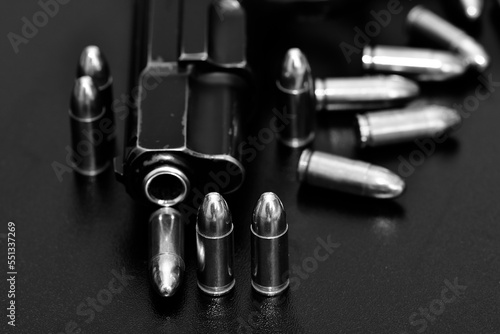 guns and bullets. Photograph of a black pistol and bullet.