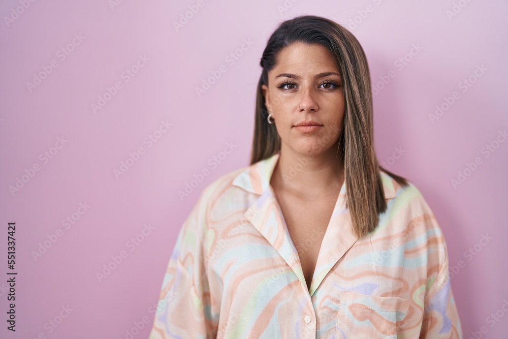 Blonde woman standing over pink background relaxed with serious expression on face. simple and natural looking at the camera. Blonde woman standing over pink background relaxed with serious expression on face. simple and natural looking at the camera.