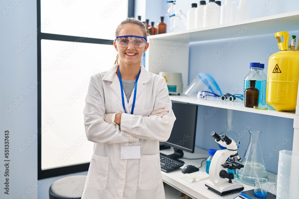 Young blonde woman wearing scientist uniform standing with arms crossed gesture at laboratory Young blonde woman wearing scientist uniform standing with arms crossed gesture at laboratory