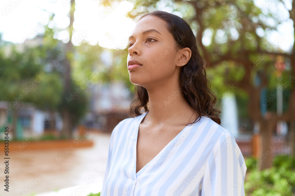 Young african american woman looking to the side with serious expression at park Young african american woman looking to the side with serious expression at park